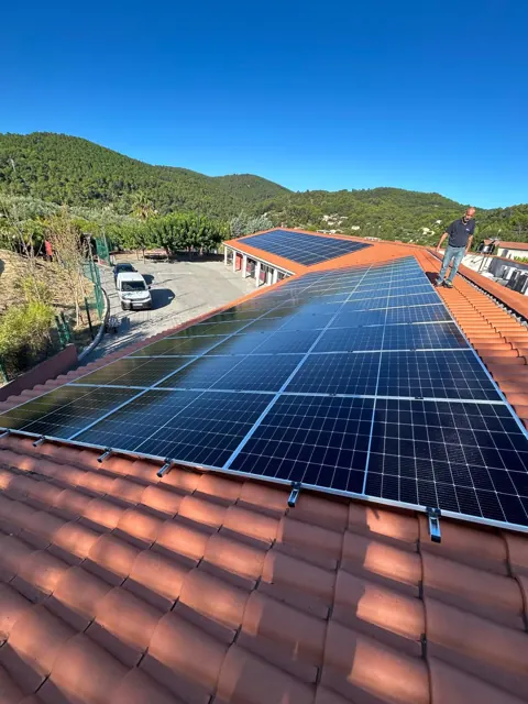 Centrale photovoltaïque sur toiture en tuiles avec vue sur les collines